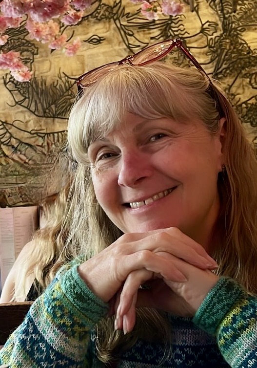 Portrait of Susan smiling, resting her chin on her hands