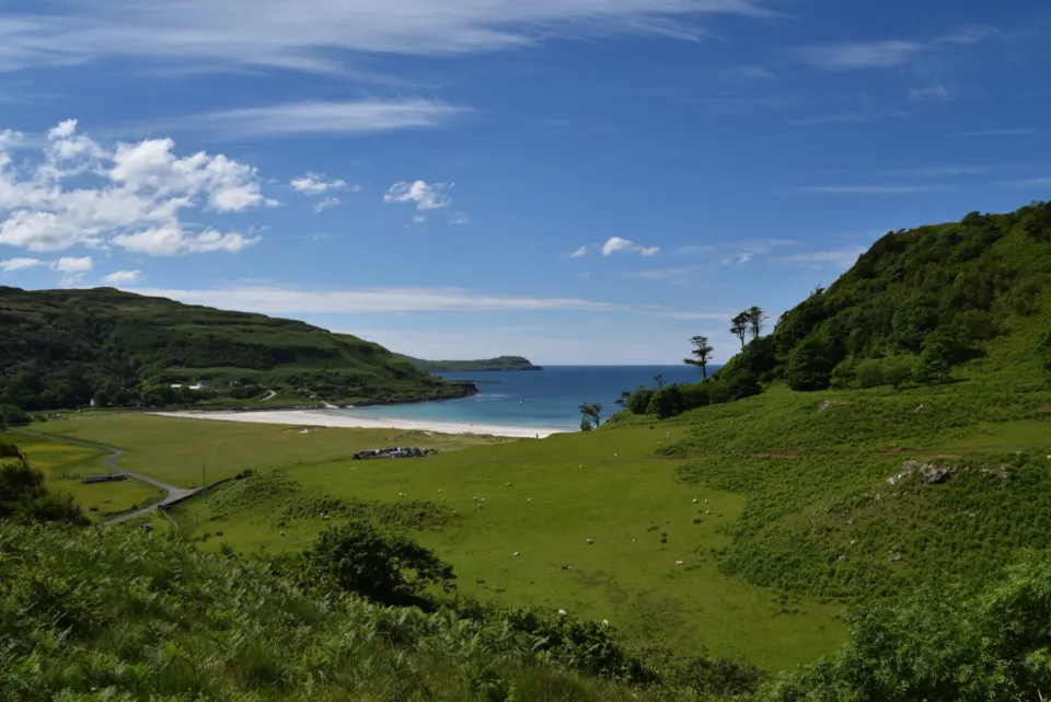 A green glen running down to a quiet bay on the west coast of Scotland